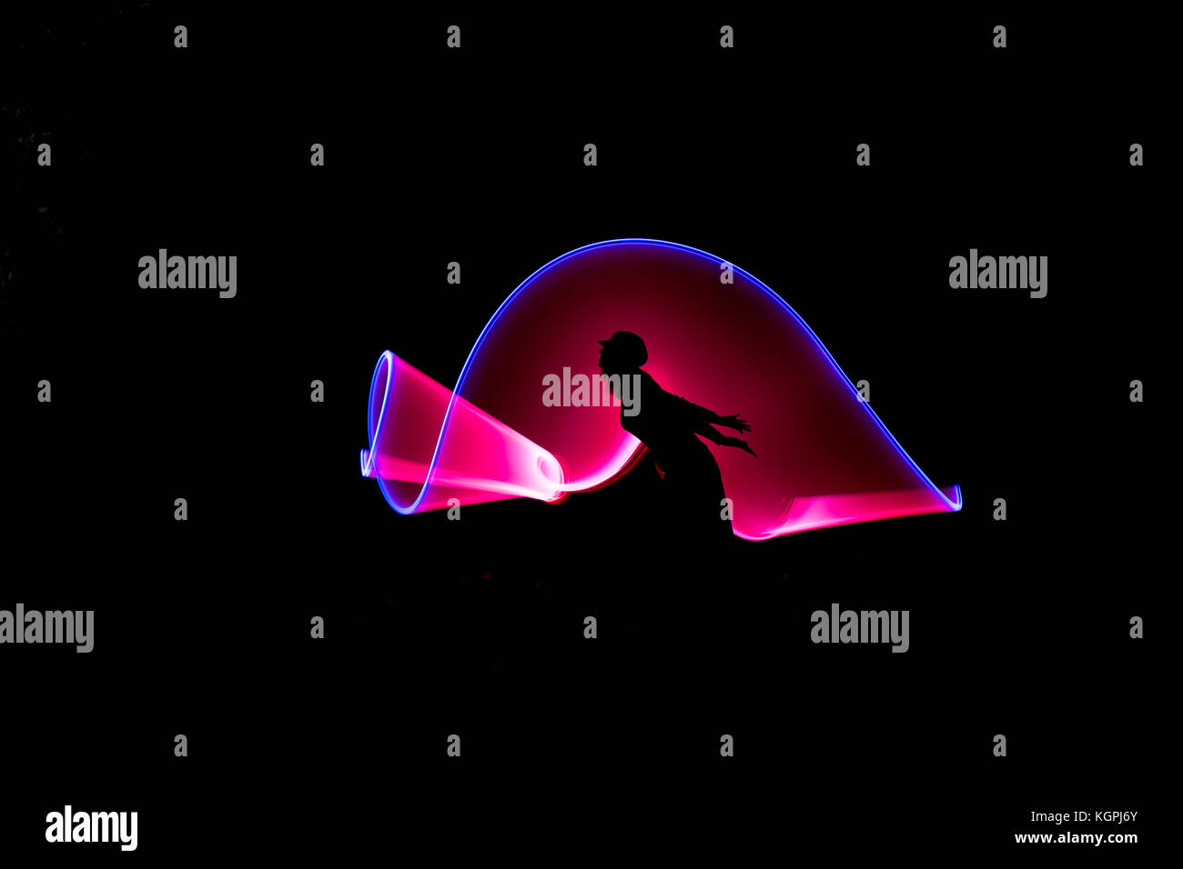 Lichtmalerei Fotografie mit Silhouette der isolierten Frau (Seitenansicht) in Blackout. Stockfoto