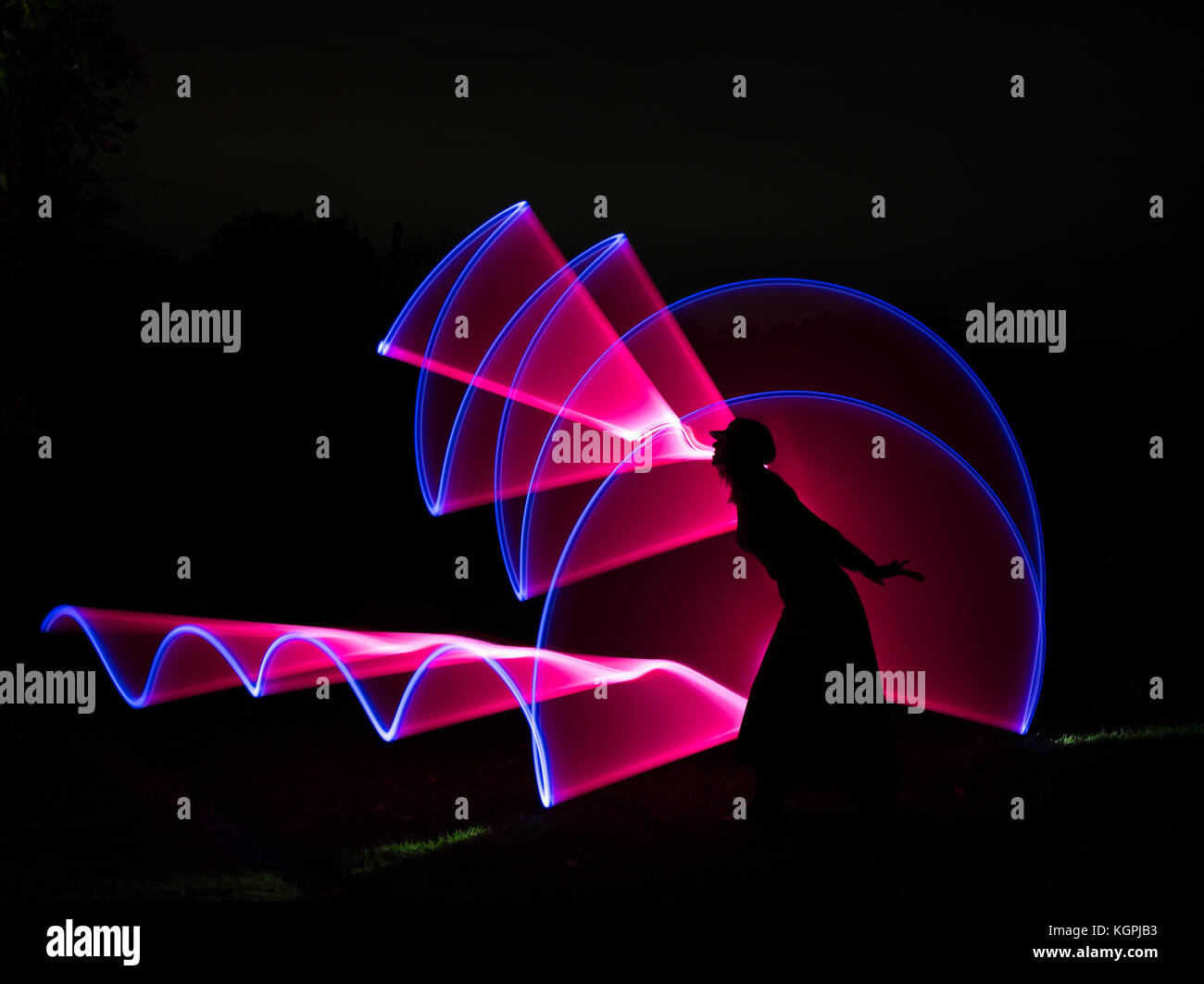 Licht Malerei Fotografie mit Silhouette der isolierten Frau in Blackout-Nacht-Szene. Stockfoto