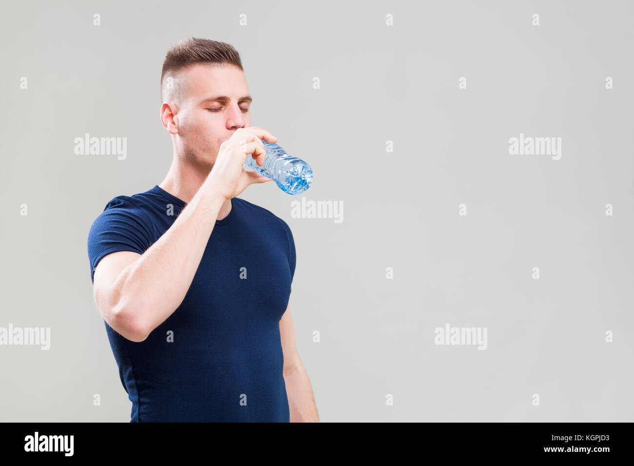 Studio shot Bild junger sportlicher Mann, trinken Wasser ist. Stockfoto