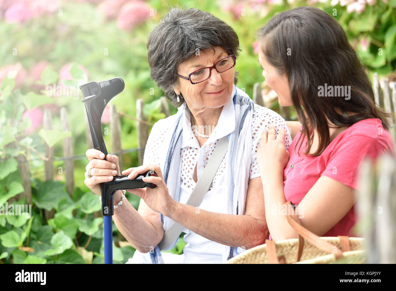 Ältere Frau mit nach Hause Betreuungsperson im Park sitzen Stockfoto