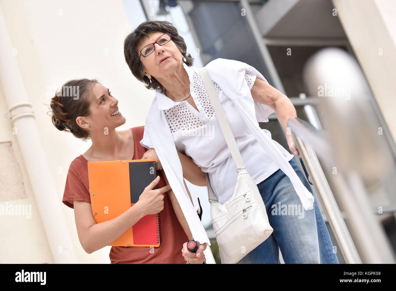 Home Pflegeperson helfen behinderte Frau, die Treppe Stockfoto