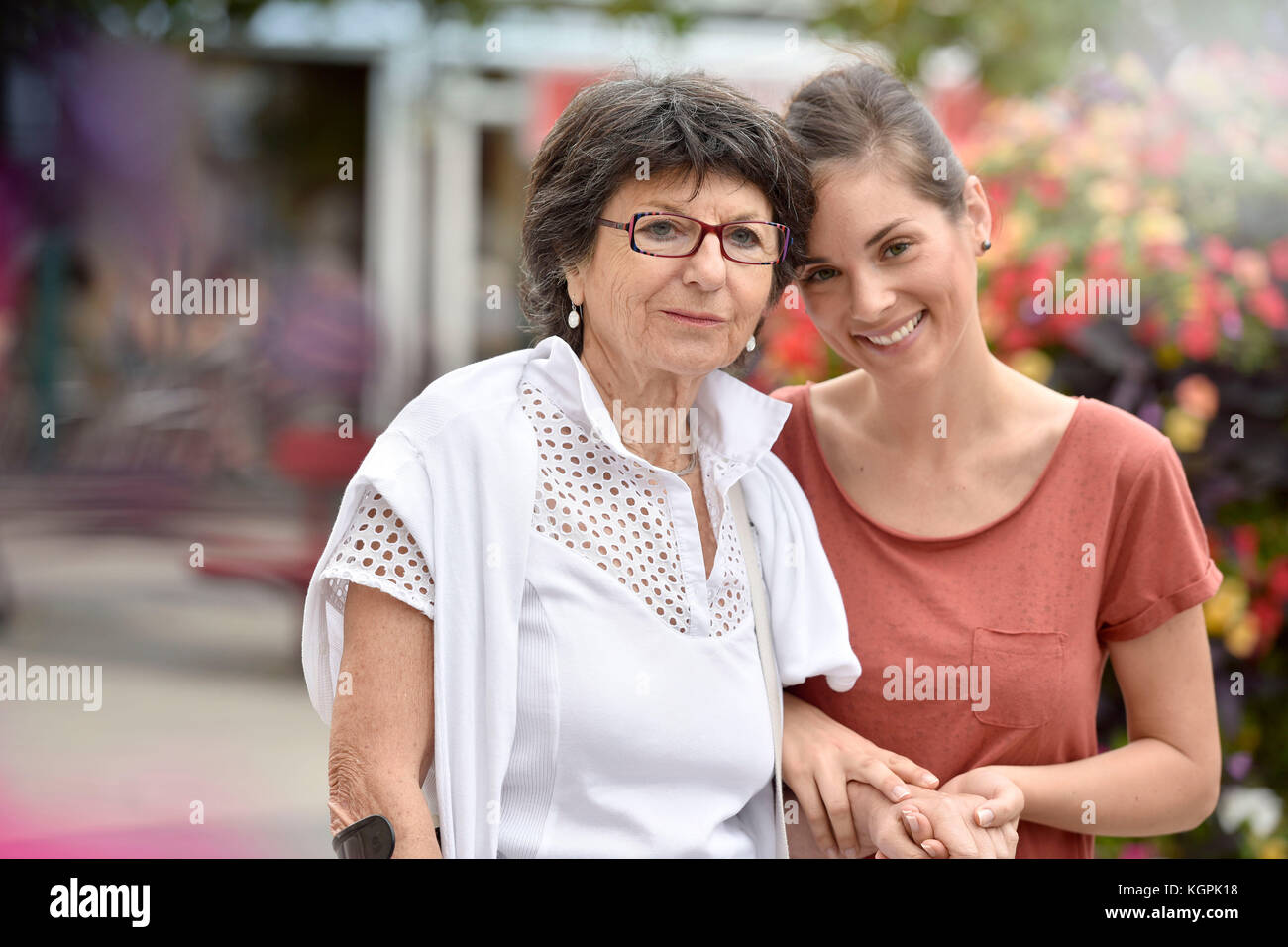 Home Pflegeperson helfen behinderte Frau gehen mit krücke Stockfoto