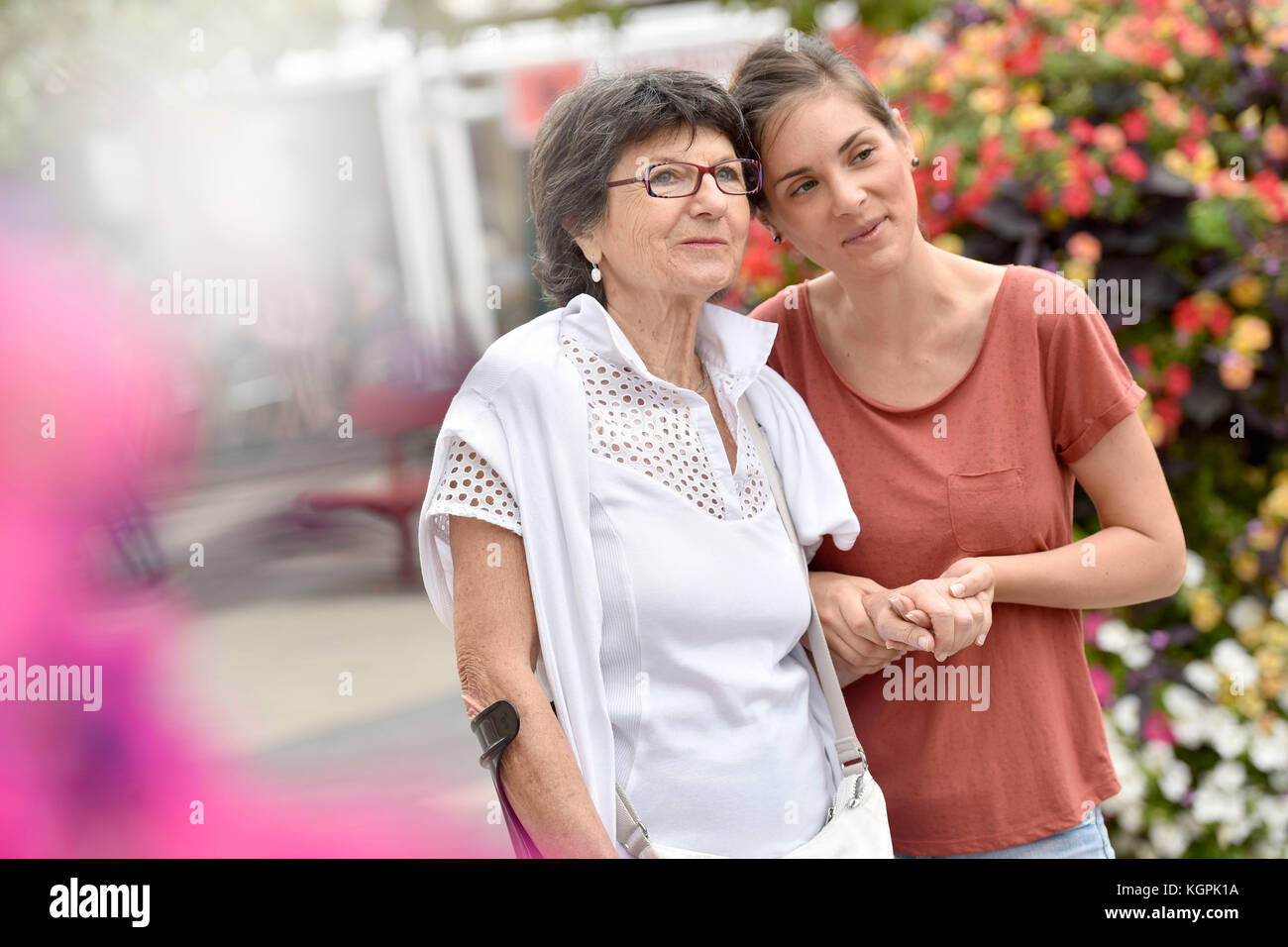 Home Pflegeperson helfen behinderte Frau gehen mit krücke Stockfoto