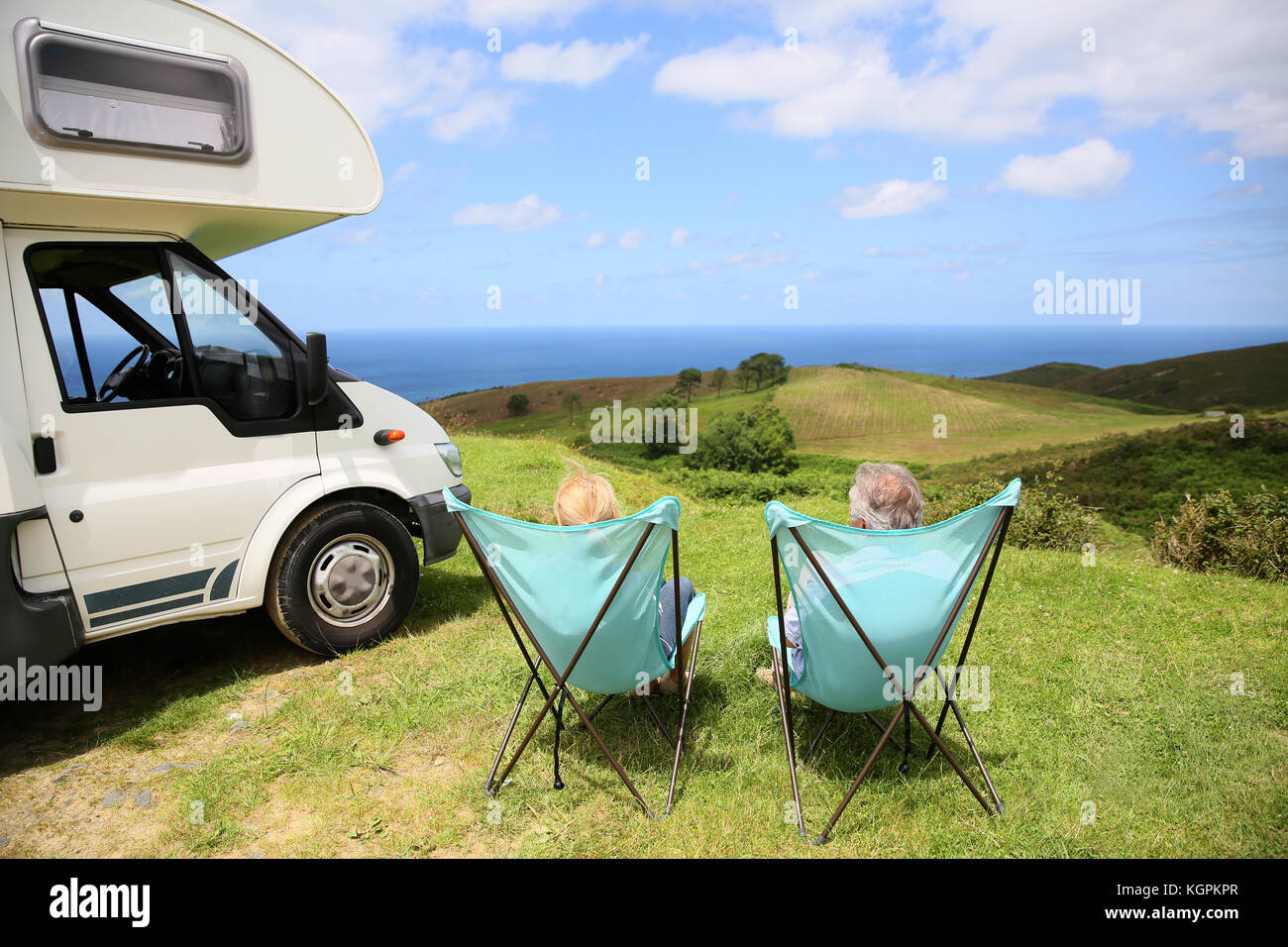 Senior paar entspannende im Camping Klappstühle, Meer Landschaft Stockfoto