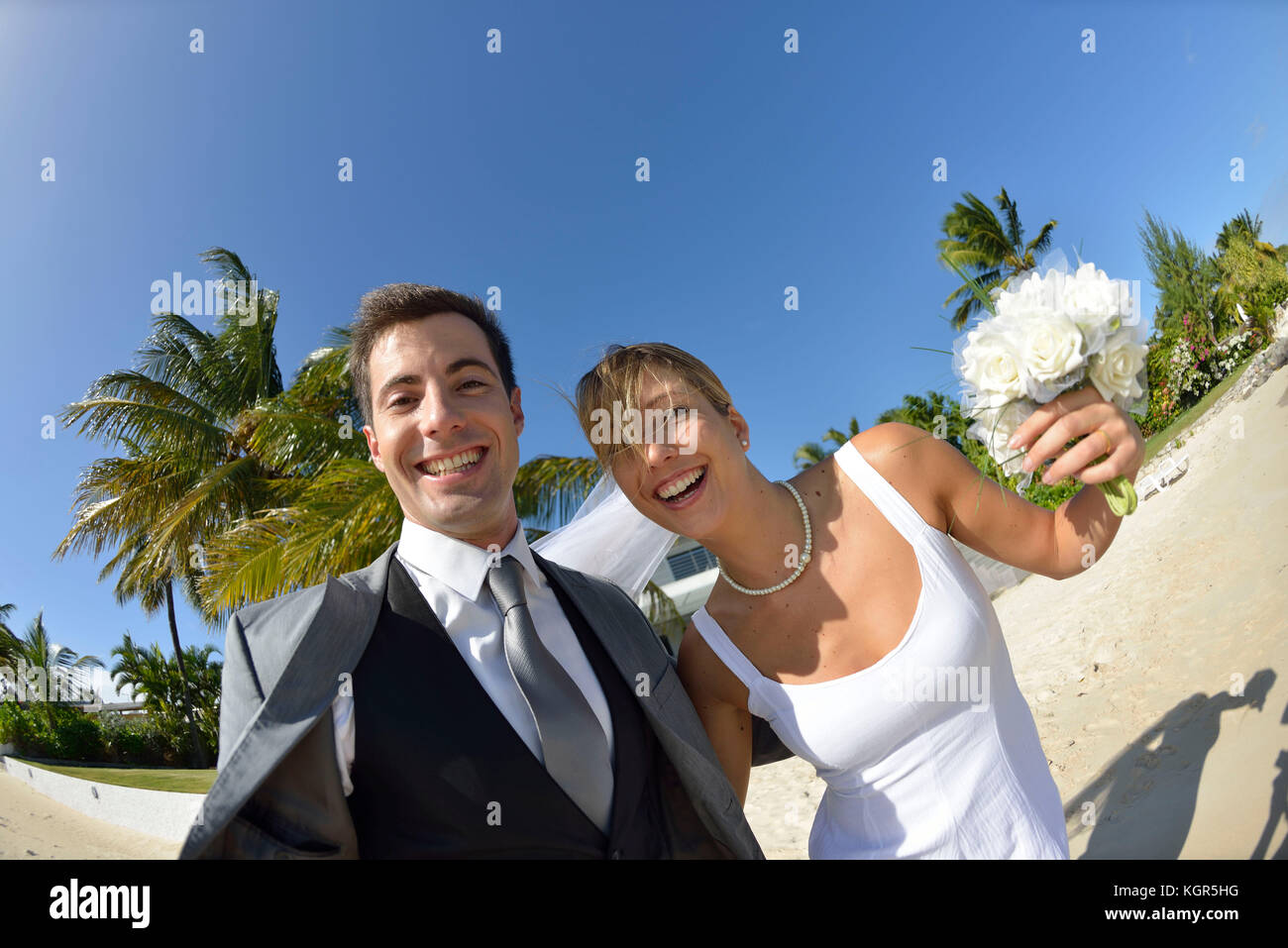 Frisch verheiratete Ehepaar zu Fuß am Strand Stockfoto