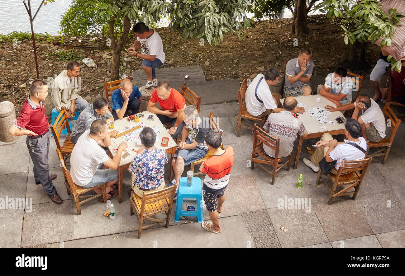 Guilin, China - 14. September 2017: Männer spielen Karten in einem Park von Lijiang River Bank. Stockfoto