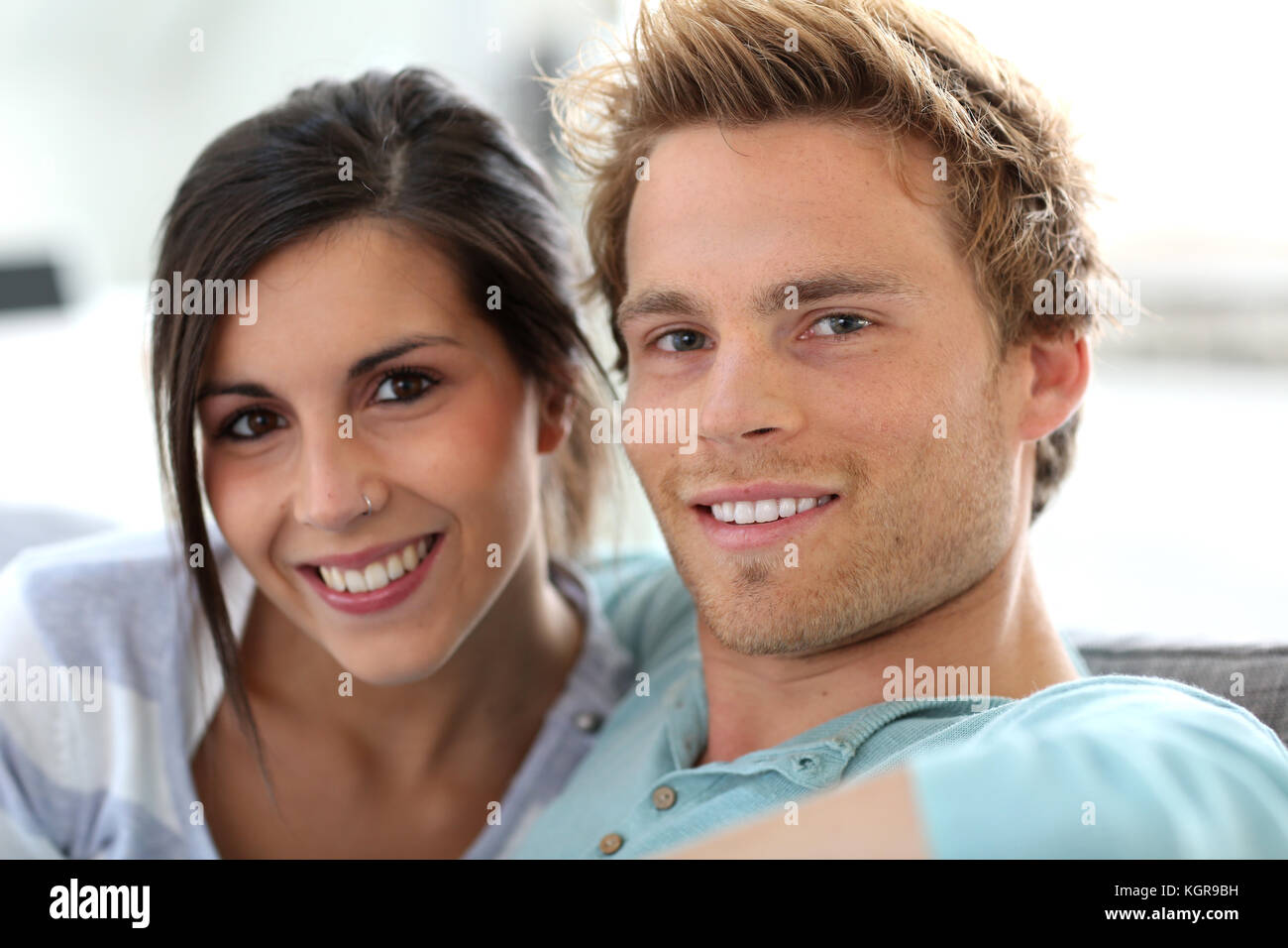 Lächelnde junge Paar entspannende im Sofa zu Hause Stockfoto