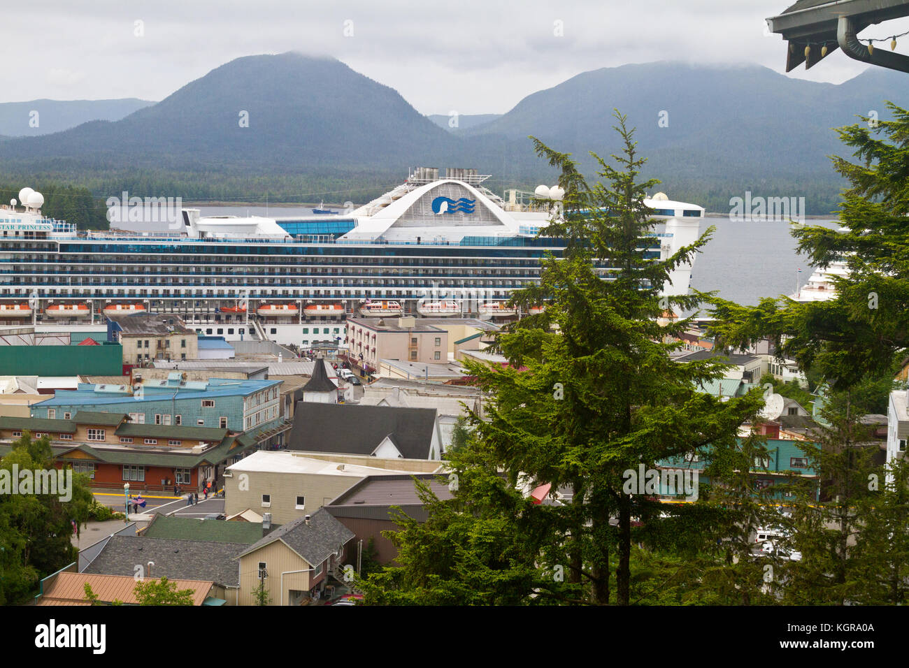 Einen erhöhten Blick auf die Innenstadt von Ketchikan, Alaska mit dem Kreuzfahrtschiff Star Princess im Hintergrund. Stockfoto