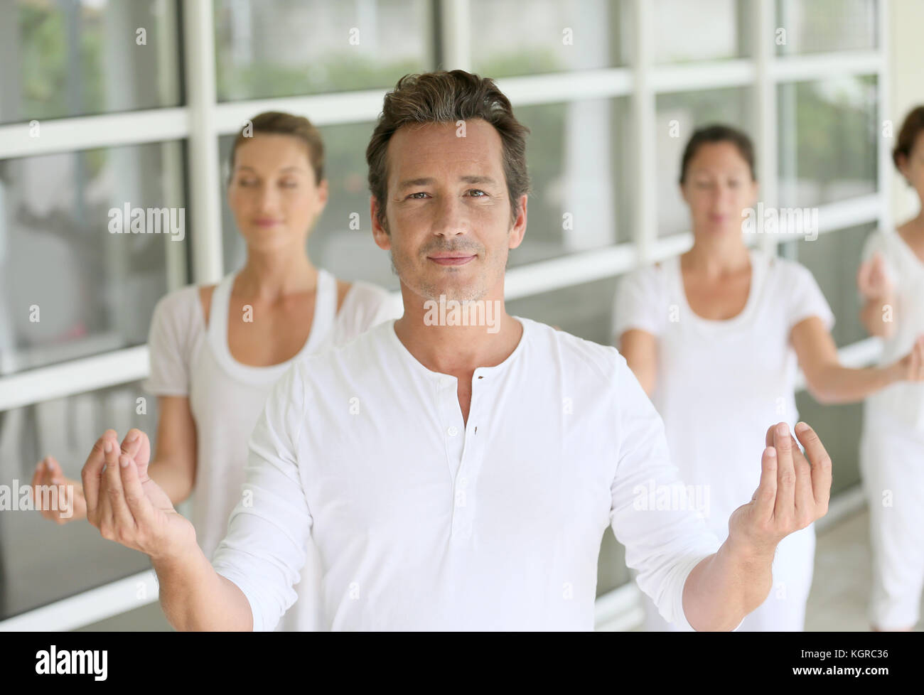 Reifer Mann unter Gruppe Yoga Übungen Stockfoto