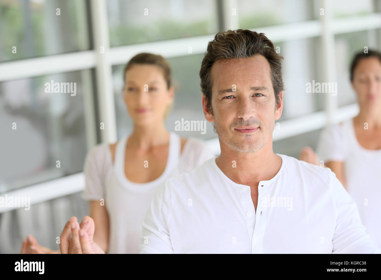 Reifer Mann unter Gruppe Yoga Übungen Stockfoto