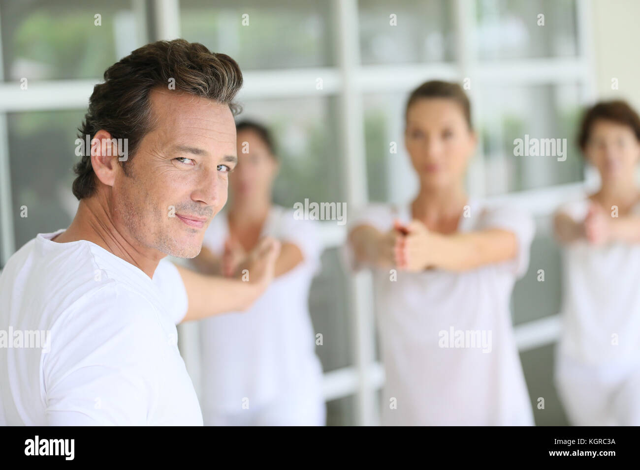 Reifer Mann unter Gruppe Yoga Übungen Stockfoto
