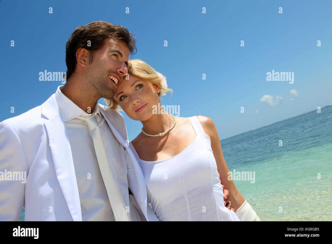 Frisch verheiratete Ehepaar zu Fuß am Sandstrand Stockfoto