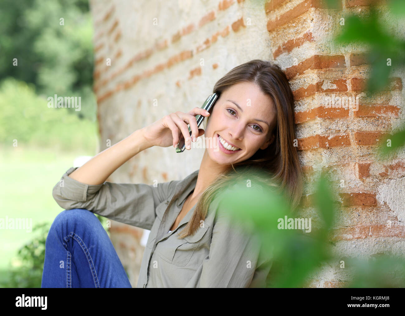 Süße Mädchen im Haus Garten, am Telefon zu sprechen Stockfoto