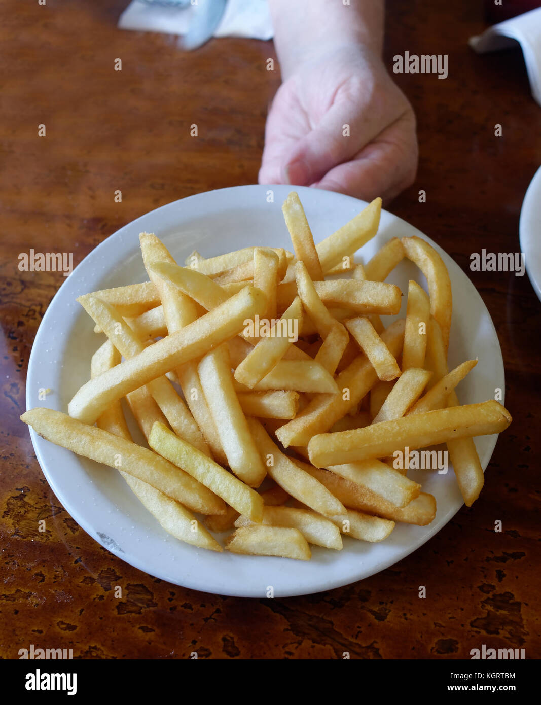 Hand, die eine Platte von heißen Diner Chips. Stockfoto