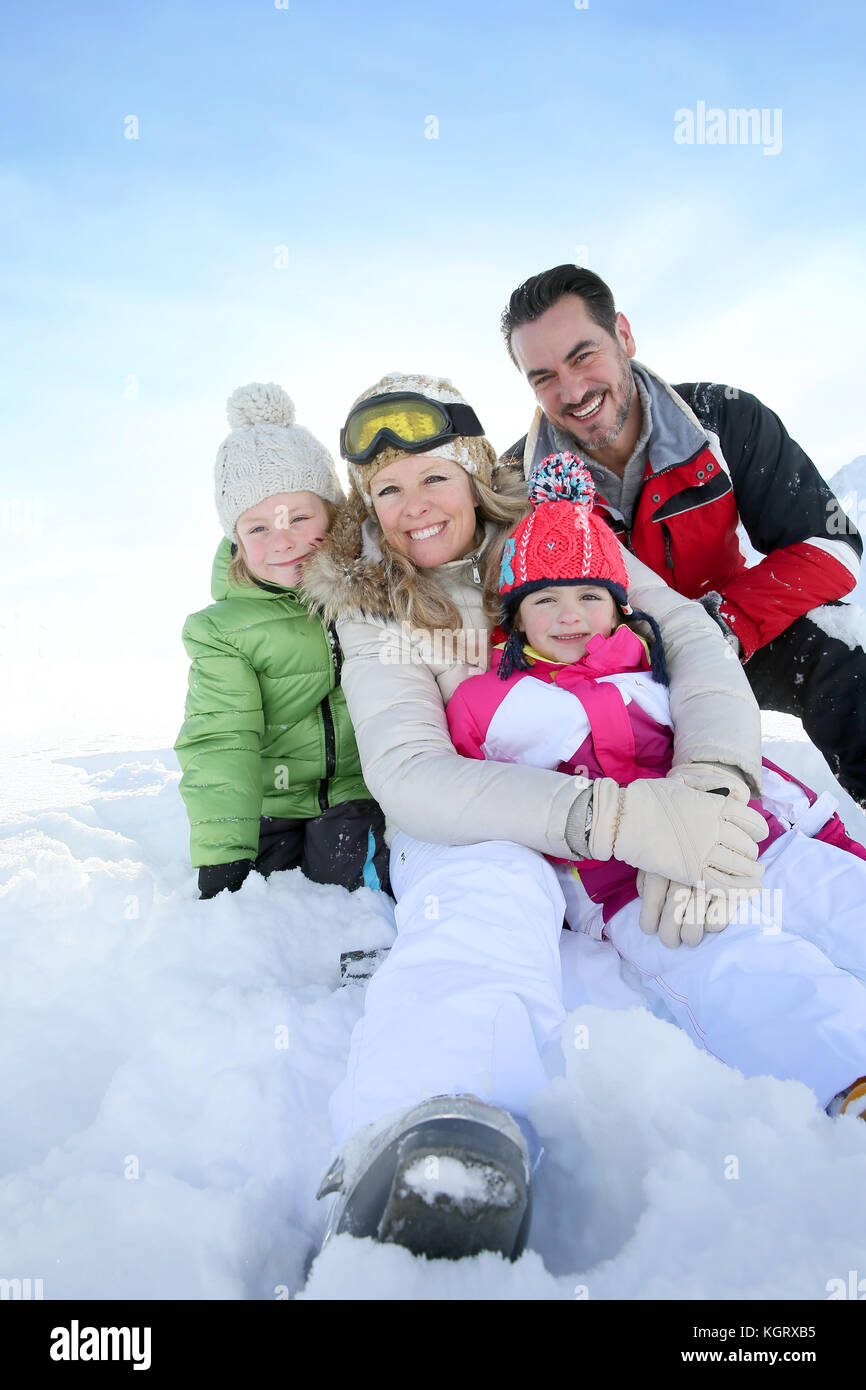 Freundliche Familie sitzt im Schnee Stockfoto