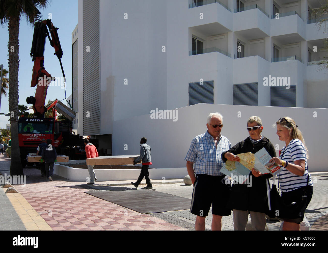 Einige Touristen Blick auf die Landkarte vor einem Hotel auf dem Strand Arenal im Frühjahr, wenn die Saison beginnt, und die Hotels bereiten Ihre Installation Stockfoto