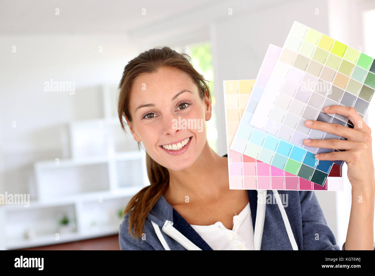 Lächelnde Mädchen holding Farbkarten Haus zu verzieren Stockfoto