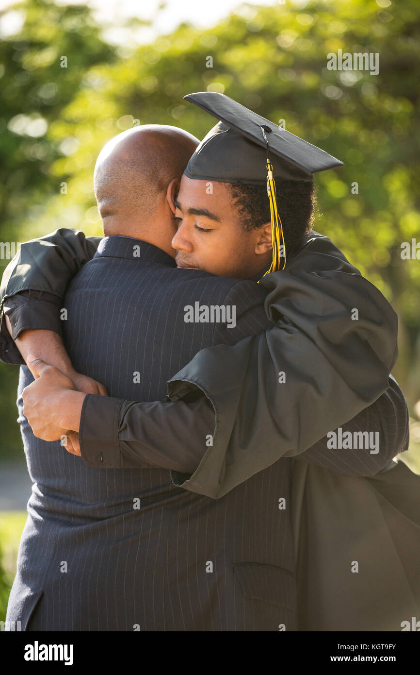 Vater seinen Sohn umarmen bei seinem Abschluss. Stockfoto