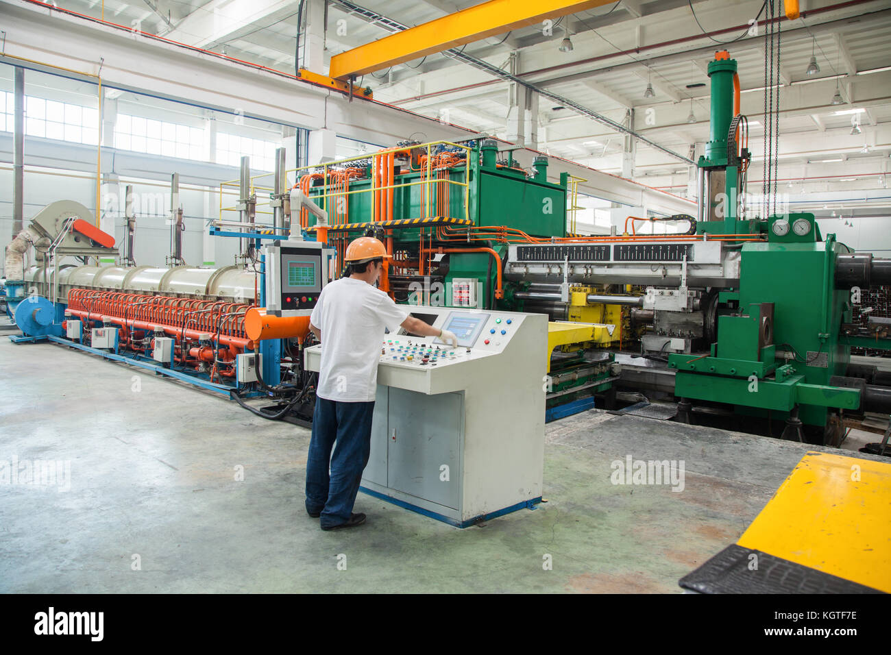 Arbeiter hinter dem Armaturenbrett in der Werkstatt für die Herstellung von Aluminiumprofilen. Aluminium Extrusion drücken Sie Stockfoto