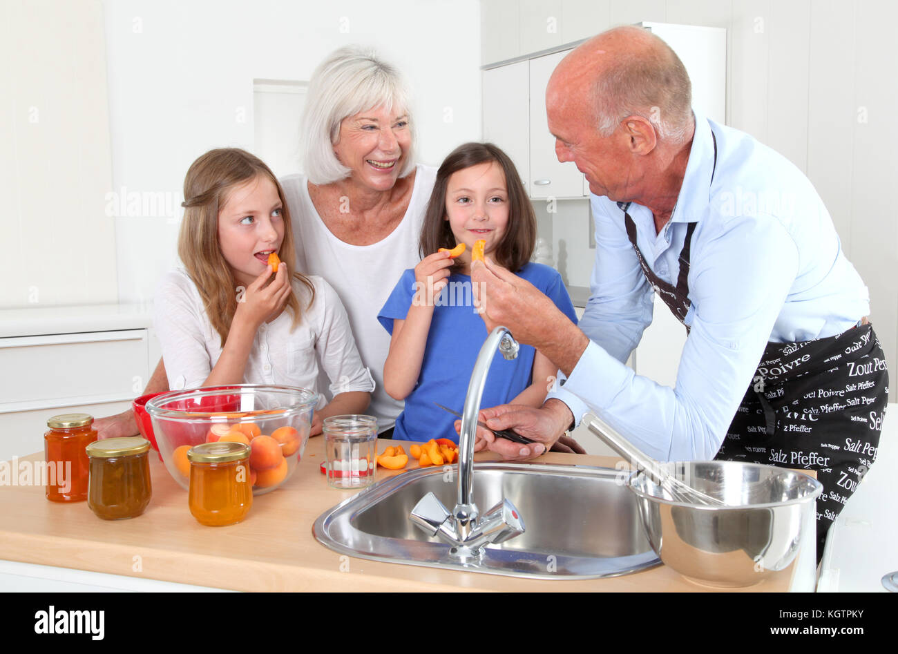 Großeltern Kochen mit Kindern in der Küche zu Hause Stockfoto