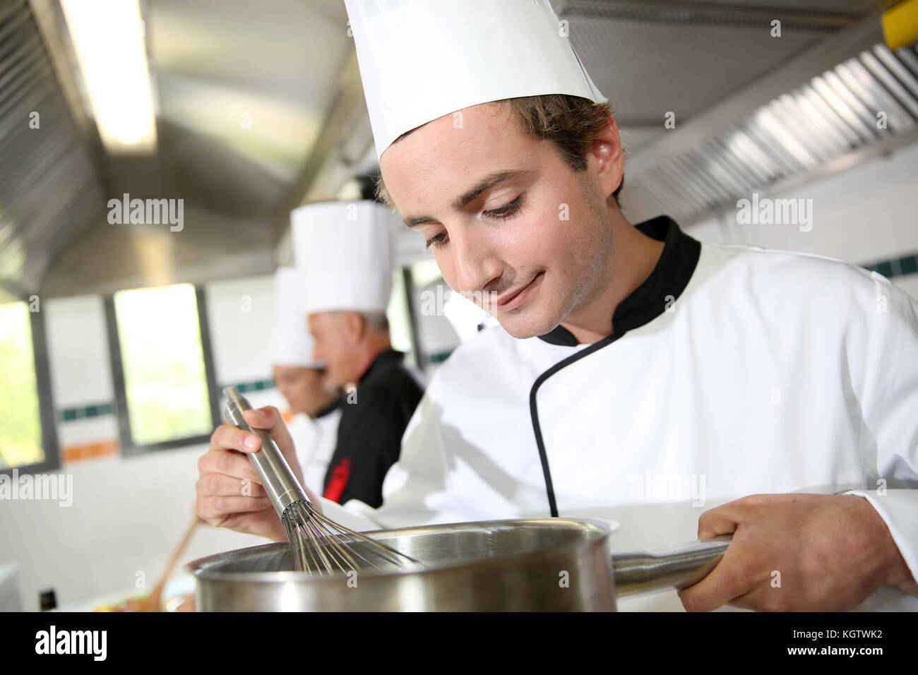 Junge Koch im Restaurant Küche Zubereitung Sauce Stockfoto