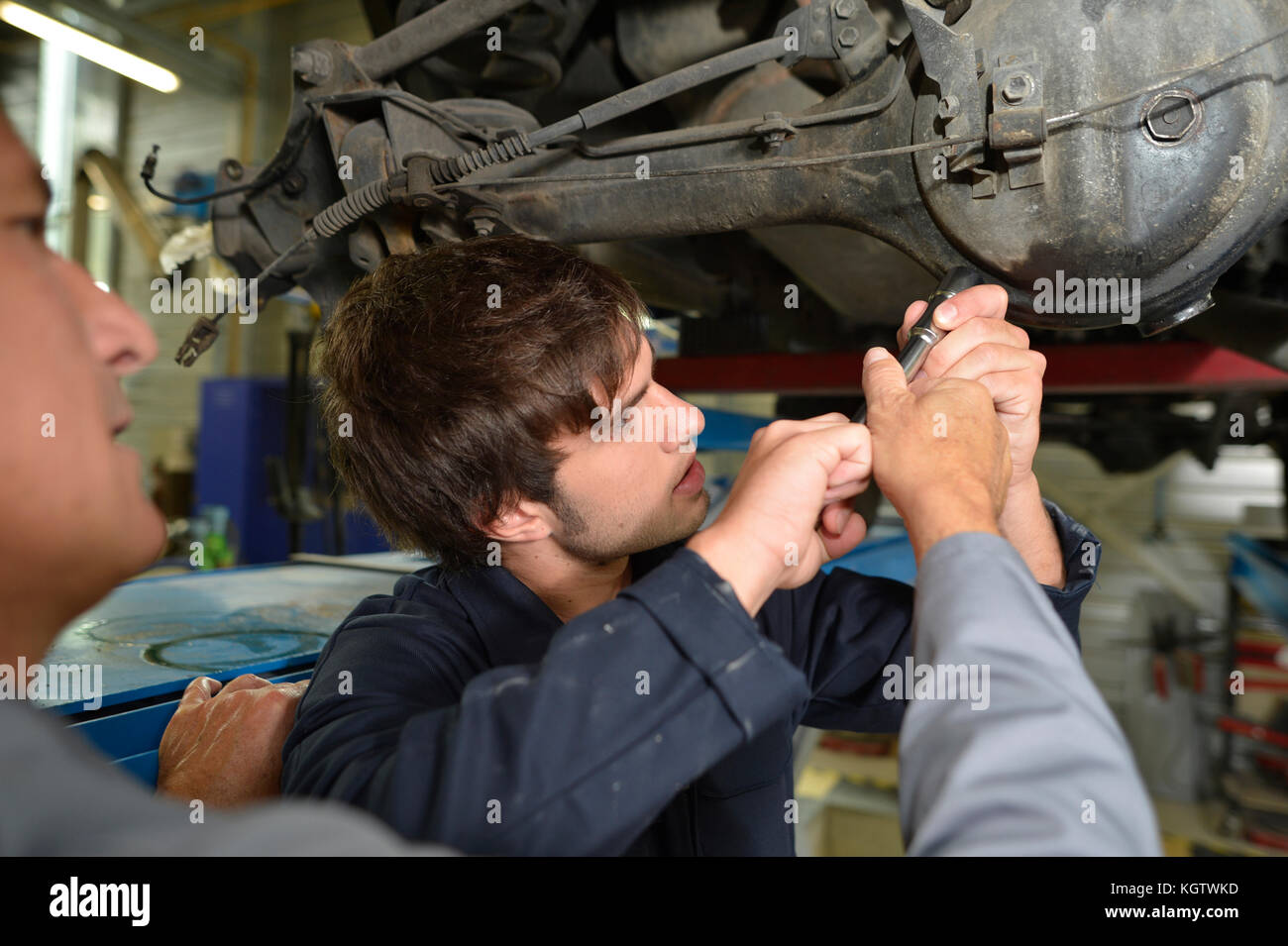 Mechanik Lehrer mit Schüler im Auto Reparaturwerkstatt Stockfoto