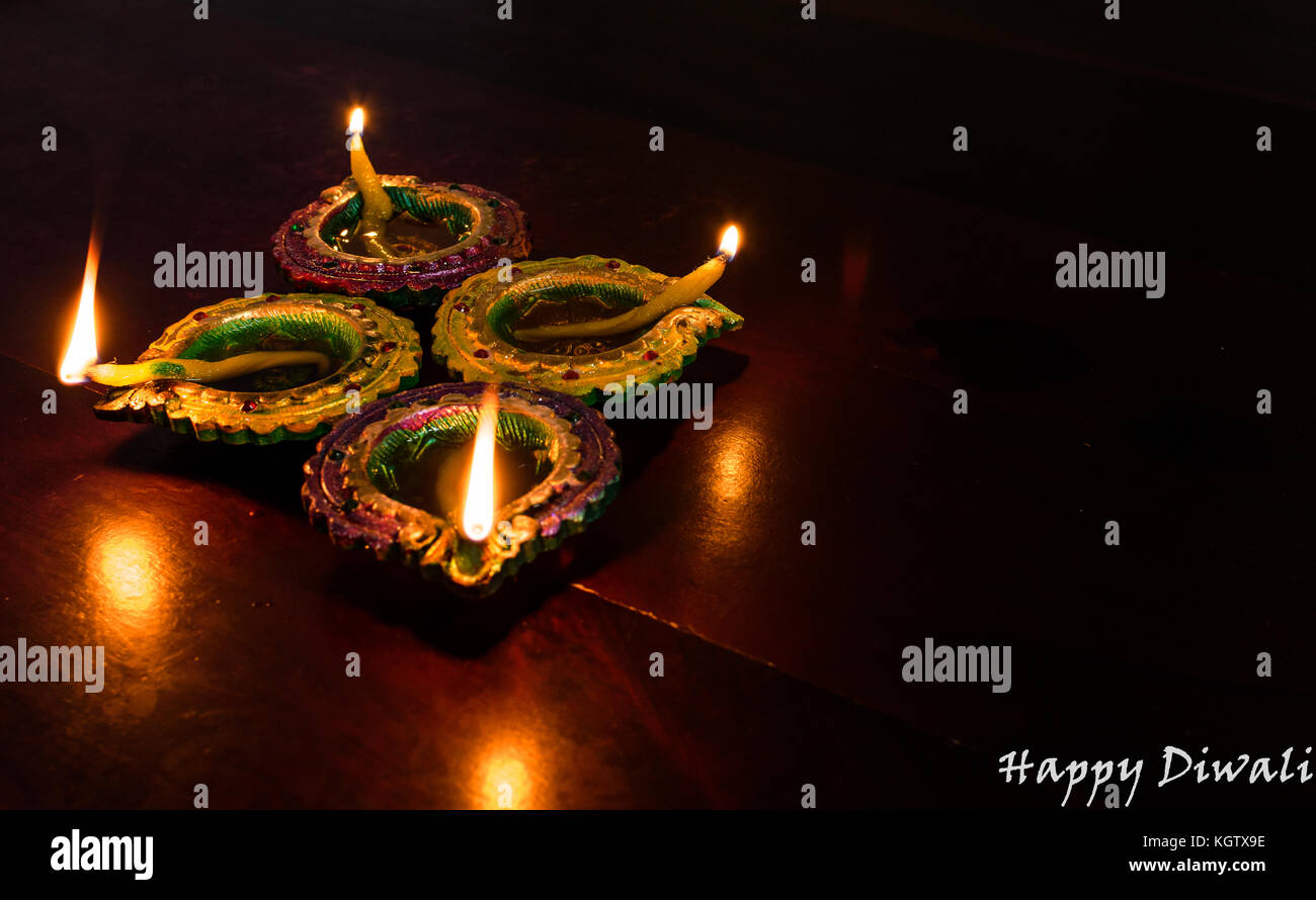 Diwali Dekorationen mit traditionellen indischen Öllampen mit selektiven Fokus auf einem Holztisch. beide Vorder- und Hintergrund sind verschwommen. Stockfoto