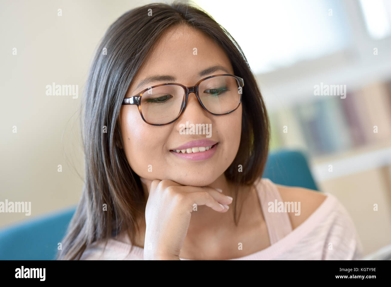 Portrait von jungen asiatischen Mädchen mit Brille lesen Zeitung Stockfoto