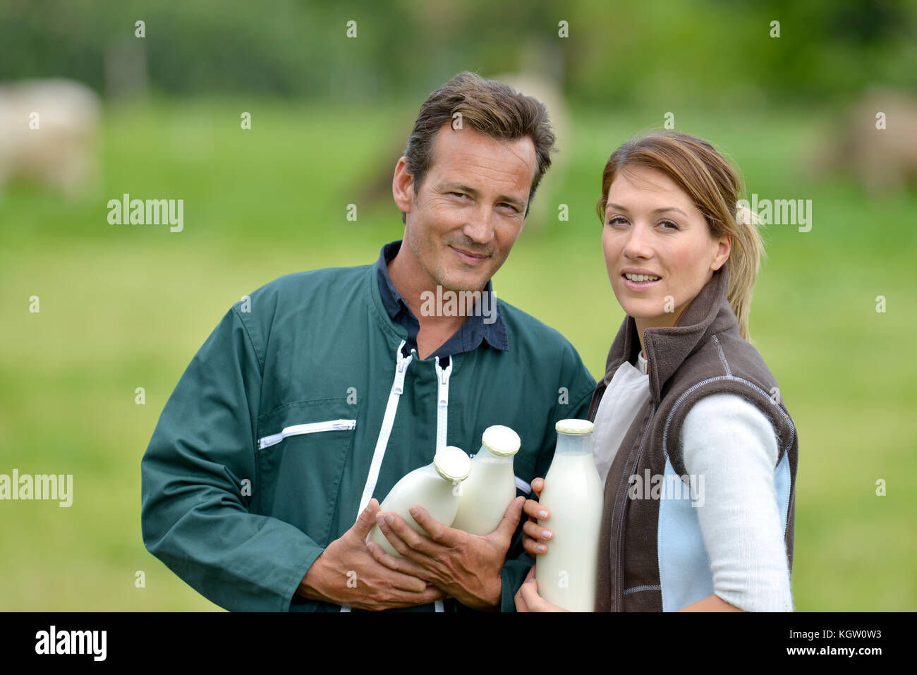 Paar Landwirte im Bereich holding Milchflaschen Stockfoto