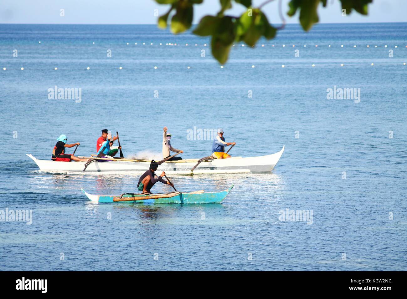Philippinische Fischer, die auf der Insel Siquijor auf den Philippinen das traditionelle Holzangeln Boot Bangka oder Banca reiten Stockfoto
