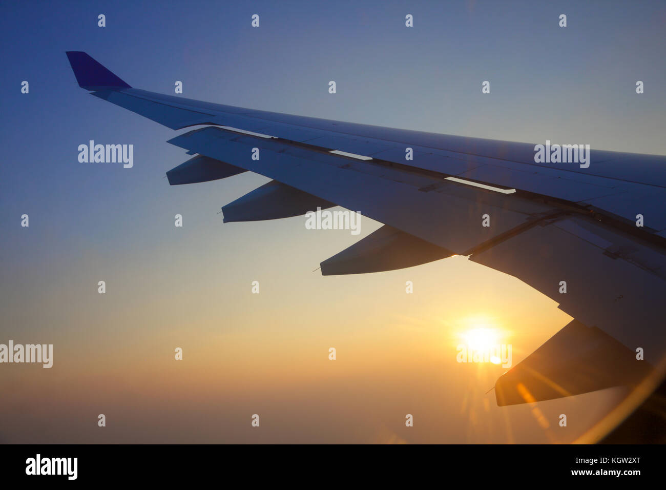 Nahaufnahme von einem Flugzeugflügel bei Sonnenuntergang Stockfoto