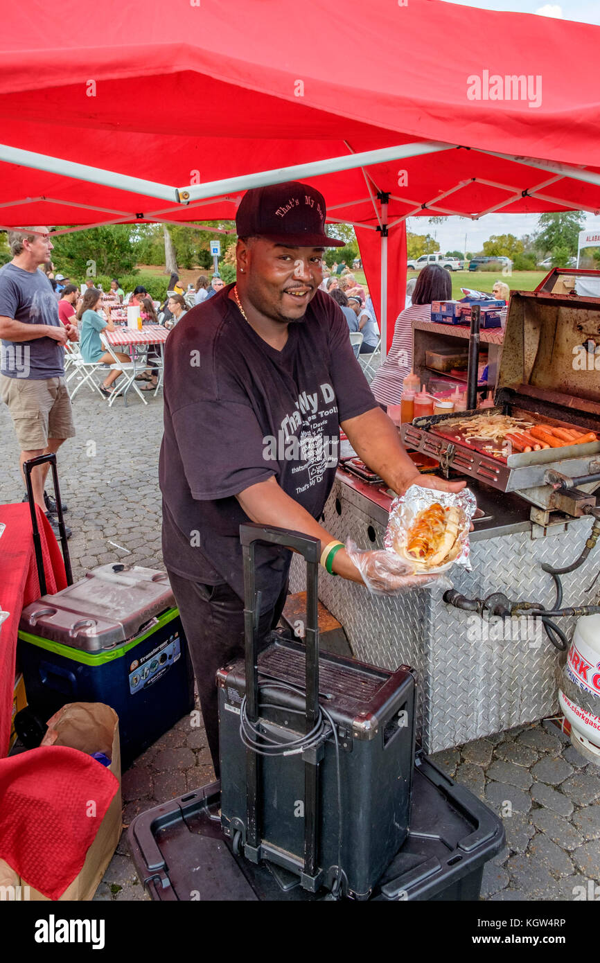 Stolz hotdog vendor Holding ein großes Hotdog mit allen Extras auf Gemeinschaftsebene street fair sein köstliches Essen in Montgomery, Alabama, USA. Stockfoto