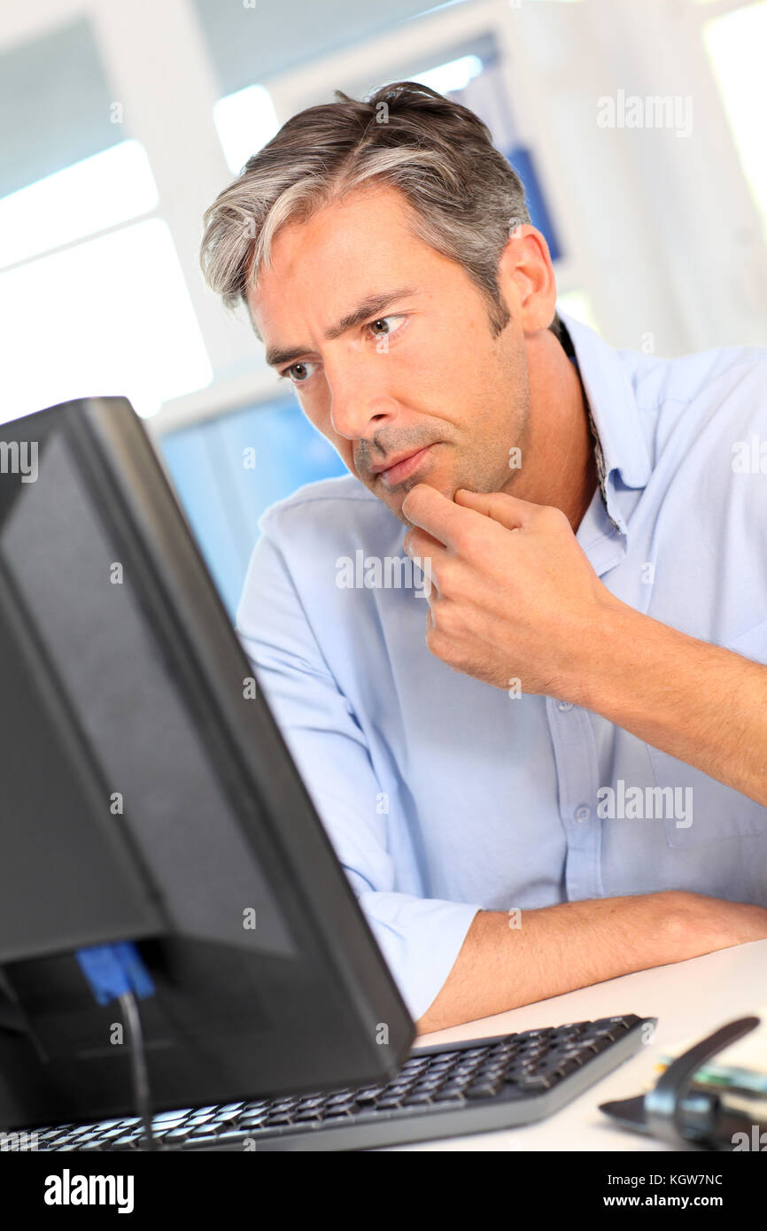 Mann bei der Arbeit im Büro mit besorgten Blick Stockfoto