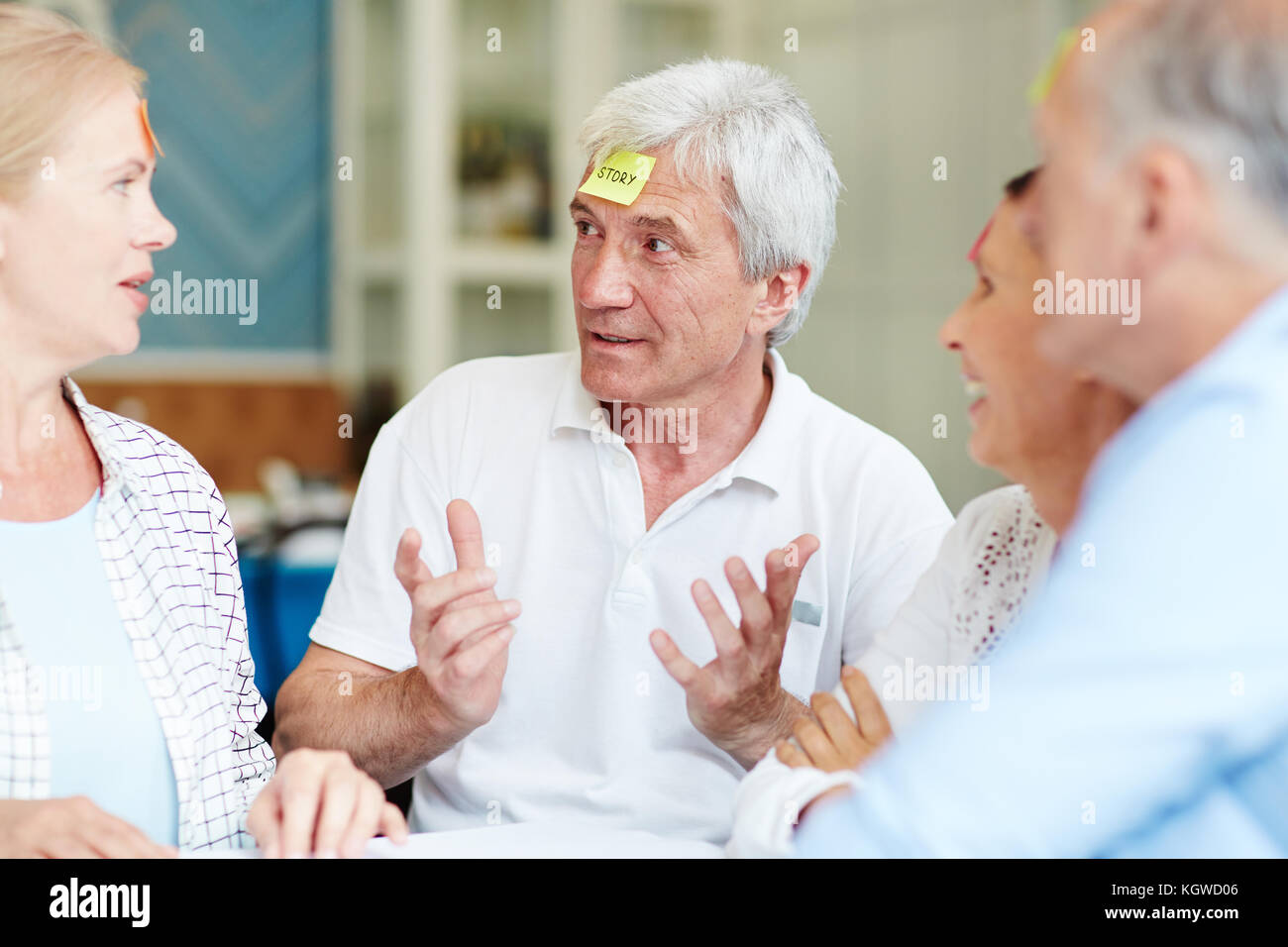 Alter Mann Abhören der Freunde beim Spielen Spiel Schätze ihr Charakter Stockfoto