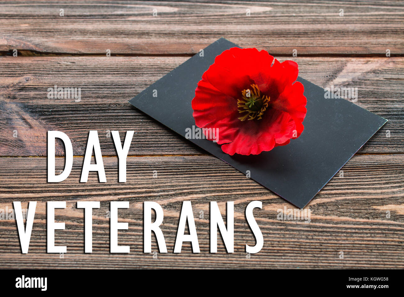 Der Text danke Veteranen in einem schwarzen Brett und Roter Mohn auf einem rustikalen Holzmöbeln Hintergrund Stockfoto