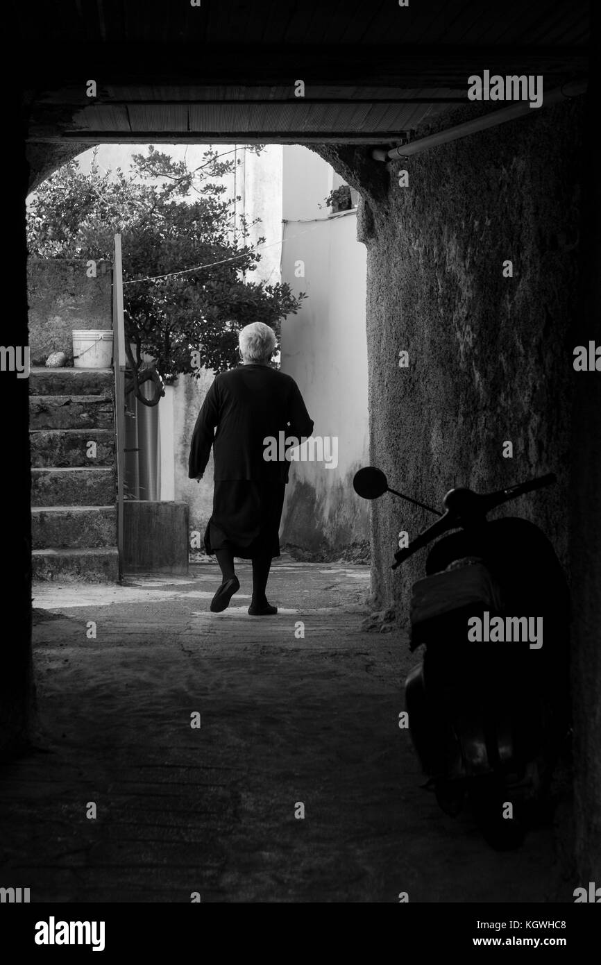 Eine alte Frau geht in die Straßen des Dorfes von aieta, Italien. aieta (auch in ajeta Form geschrieben) ist eine italienische Gemeinde von 814 Einwohnern in Stockfoto