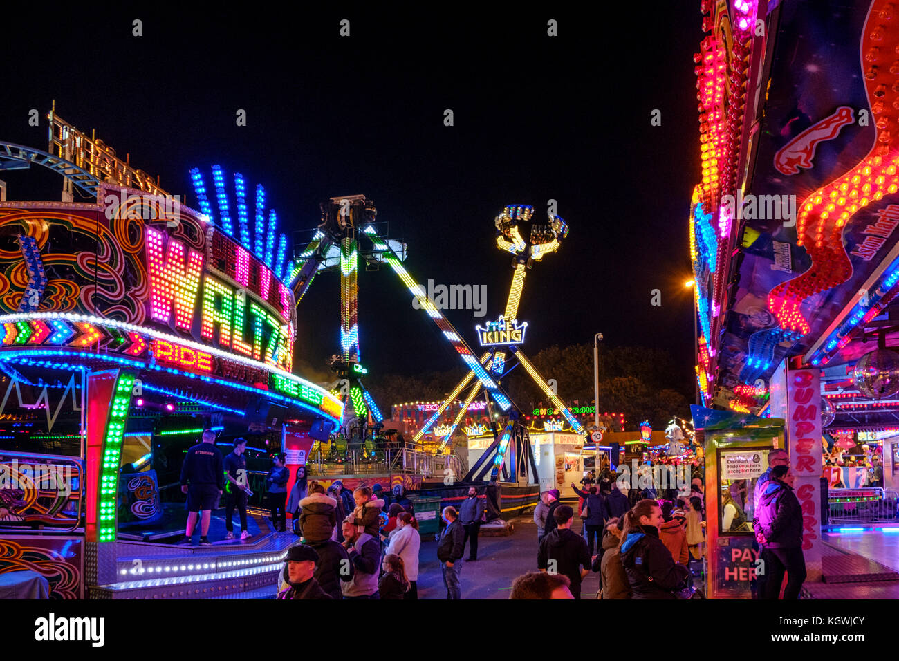 Menschen und Fahrgeschäfte in der Nacht, Goose Fair, Nottingham, England, Großbritannien Stockfoto