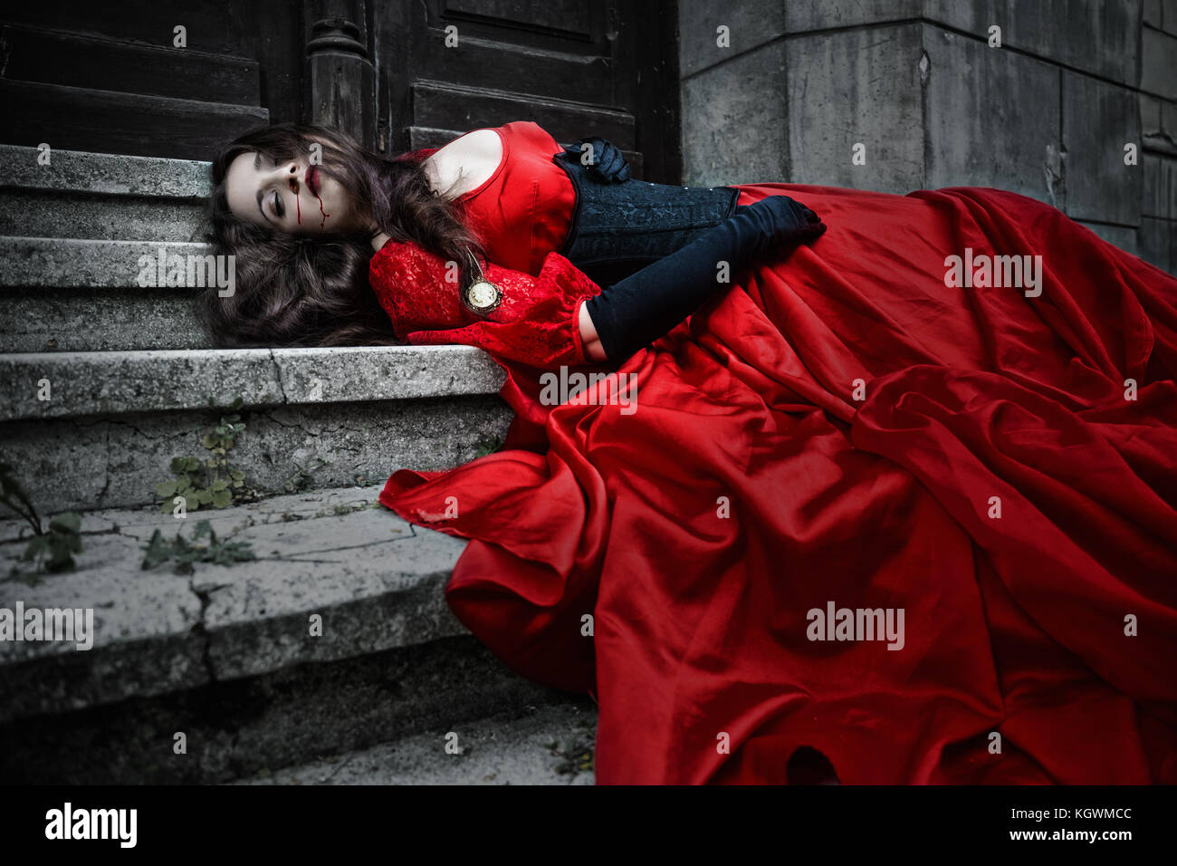 Liegen und bluten Frau in rotem Kleid im viktorianischen Stil Stockfoto