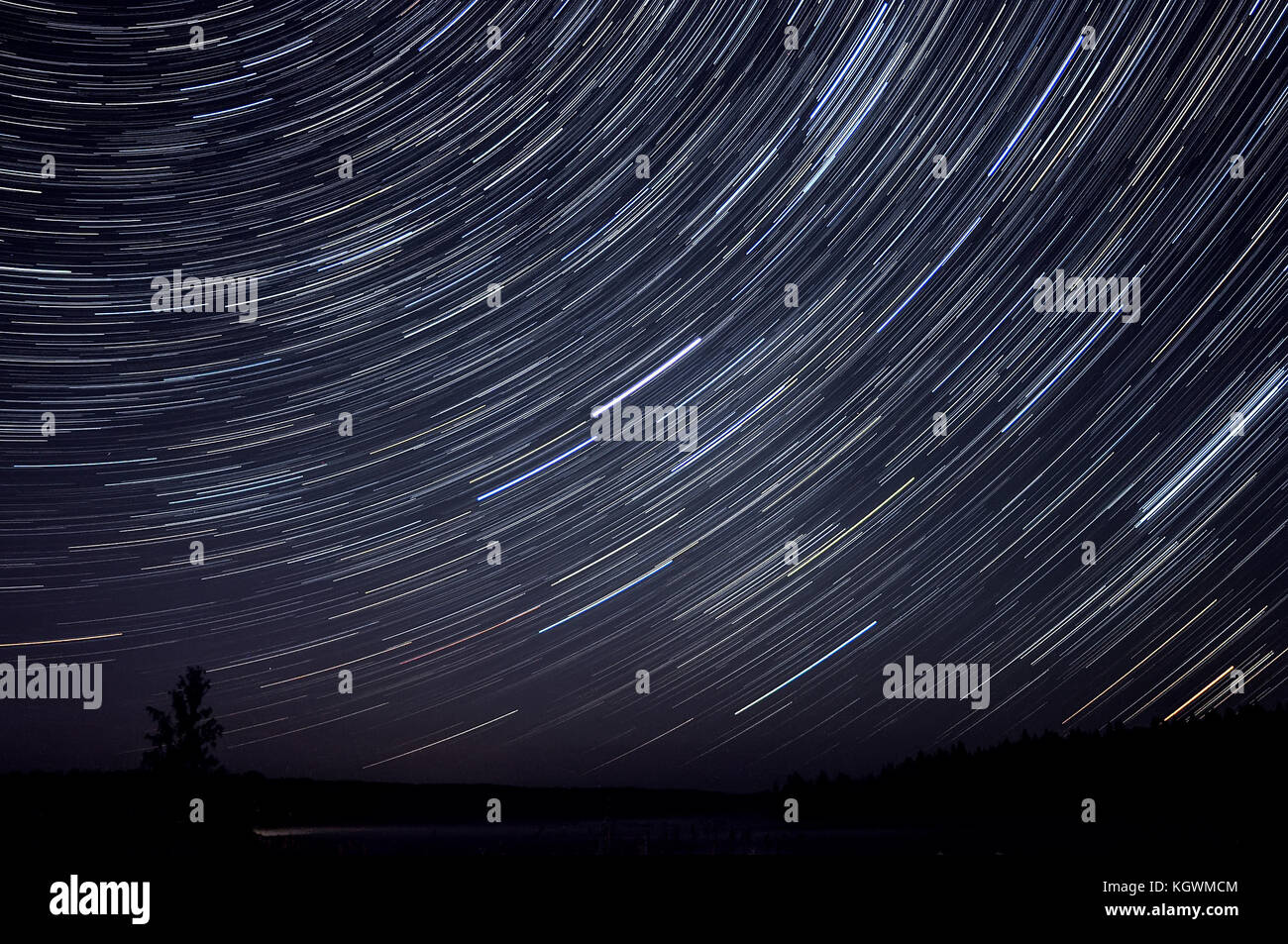 Malerischer Blick auf den See, den Wald und den Nachthimmel mit Sternen in Form von Tracks Stockfoto