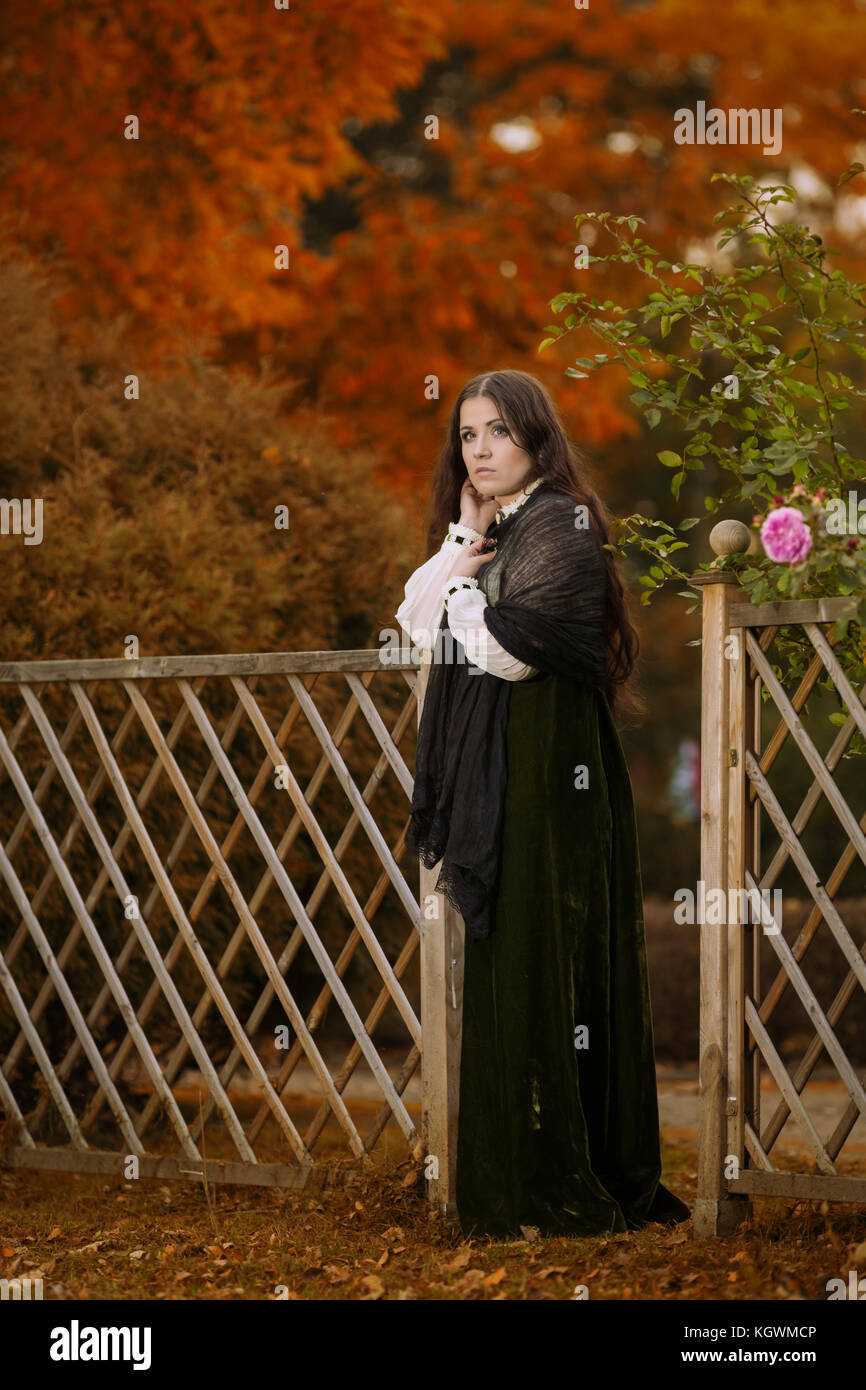 Frau im viktorianischen Kleid im Herbst Landschaft Stockfoto