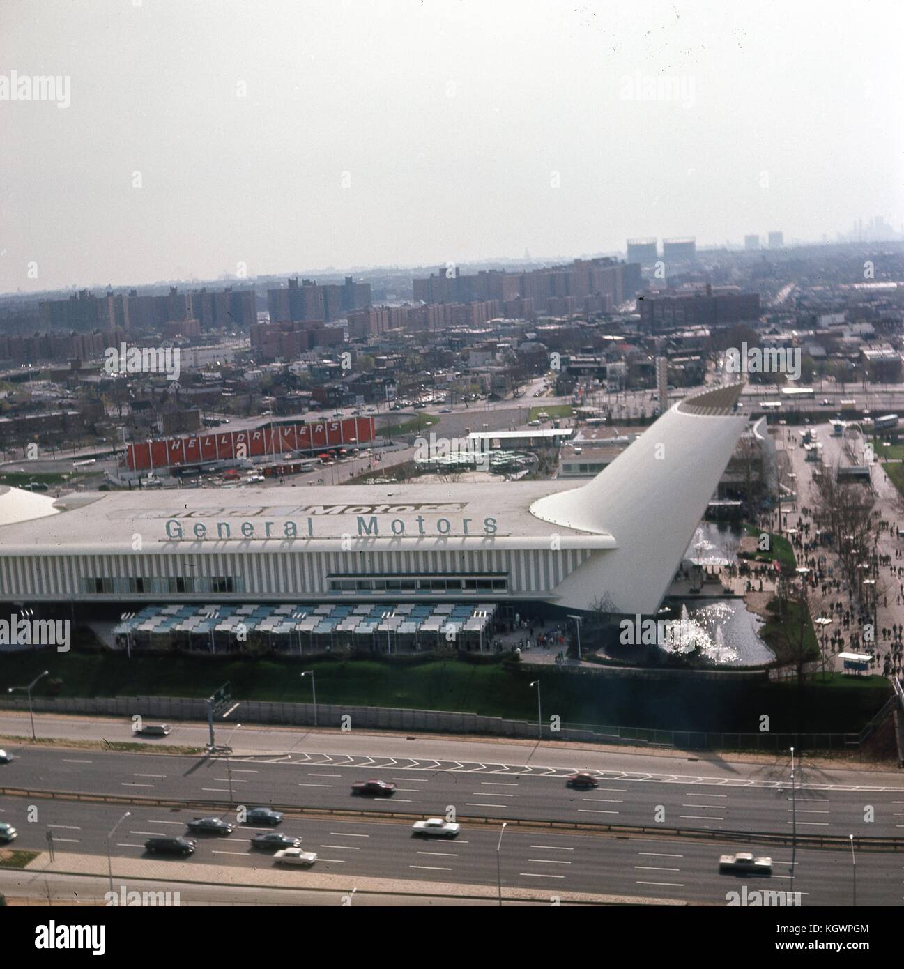 Panoramablick Blick nach Südwesten vom Aussichtsturm des New York State Pavillon auf der New York World, Flushing Meadows-Corona, Queens, New York City, Mai, 1964. die General Motors Pavillon Ausstellung erstreckt sich über den mittleren Rahmen, während Autos fahren Sie Richtung Norden und Süden entlang des Grand Central Parkway im Vordergrund. Über die GM-Ausstellung Gebäude ist die Hölle Treiber Stunt Car Track. Im rechten Frame Rand sind Besucher entlang der Straße der Vereinten Nationen, Süden, in Richtung der Kreuzung der 111. Straße und Corona Avenue im Zentrum Mittelgrund. Darüber hinaus in der Mitte zurück Stockfoto