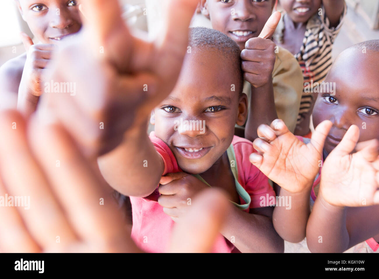 Ein Bündel von gelegentlichen ugandischen Kinder auf der Straße lachen, Lächeln, winken und Spaß vor der Kamera. Stockfoto