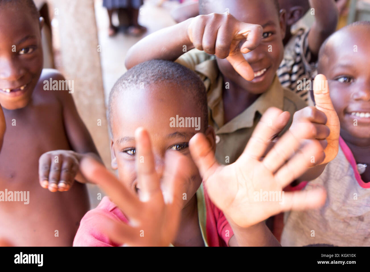 Ein Bündel von gelegentlichen ugandischen Kinder auf der Straße lachen, Lächeln, winken und Spaß vor der Kamera. Stockfoto