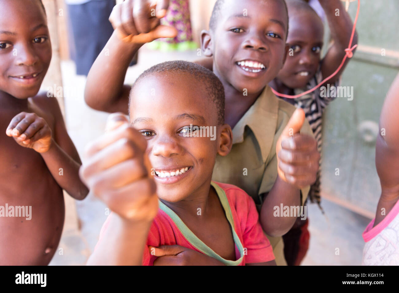 Ein Bündel von gelegentlichen ugandischen Kinder auf der Straße lachen, Lächeln, winken und Spaß vor der Kamera. Stockfoto