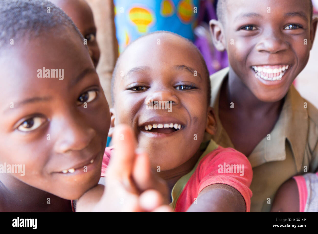 Ein Bündel von gelegentlichen ugandischen Kinder auf der Straße lachen, Lächeln, winken und Spaß vor der Kamera. Stockfoto