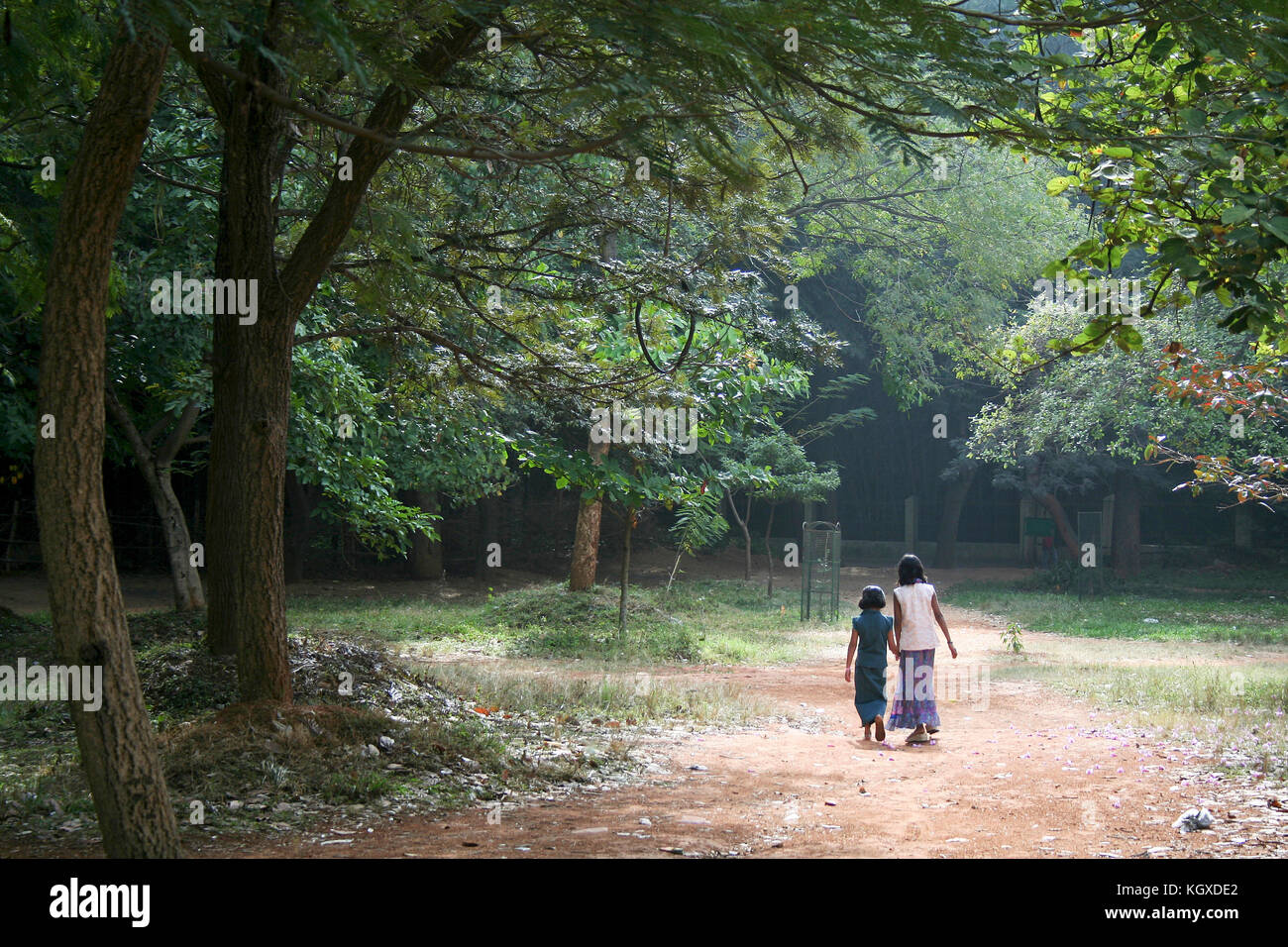 Zwei Mädchen, die gemächlich in der grünen Umgebung von einem Park entfernt Stockfoto