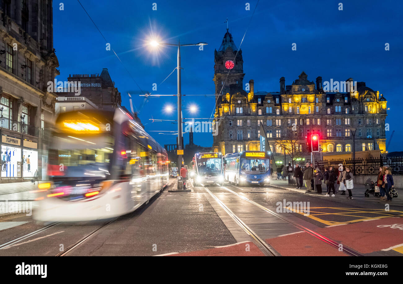 Nachtansicht der Princes Street in Edinburgh mit der Edinburgh Straßenbahn und dem Verkehr auf Langzeitbelichtung in Schottland, Großbritannien. Stockfoto