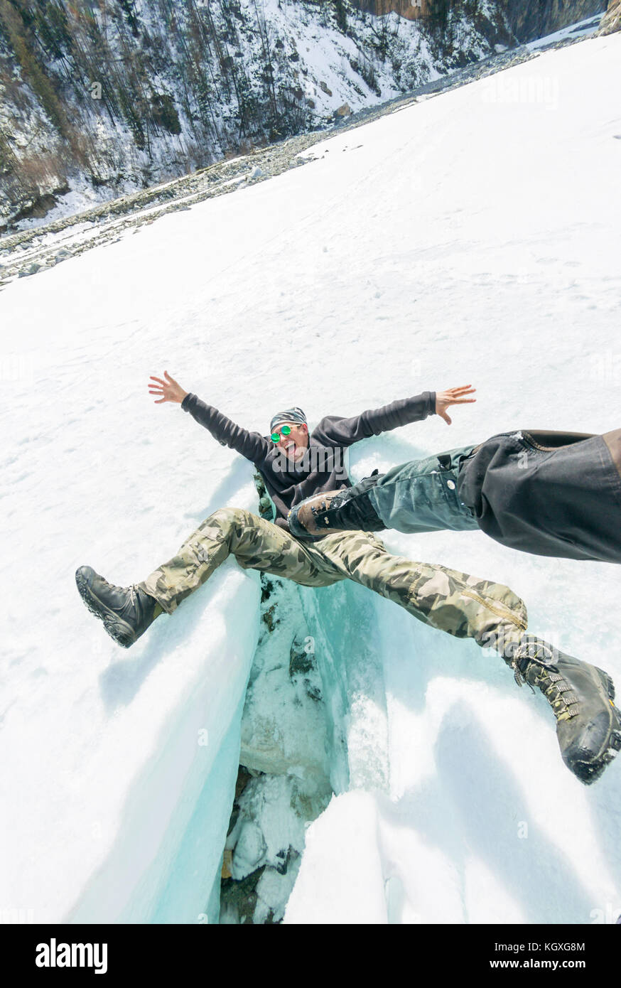 Der Mann fällt aus die Schreie von einem Schlag auf das Knacken des Gletschers. Stockfoto