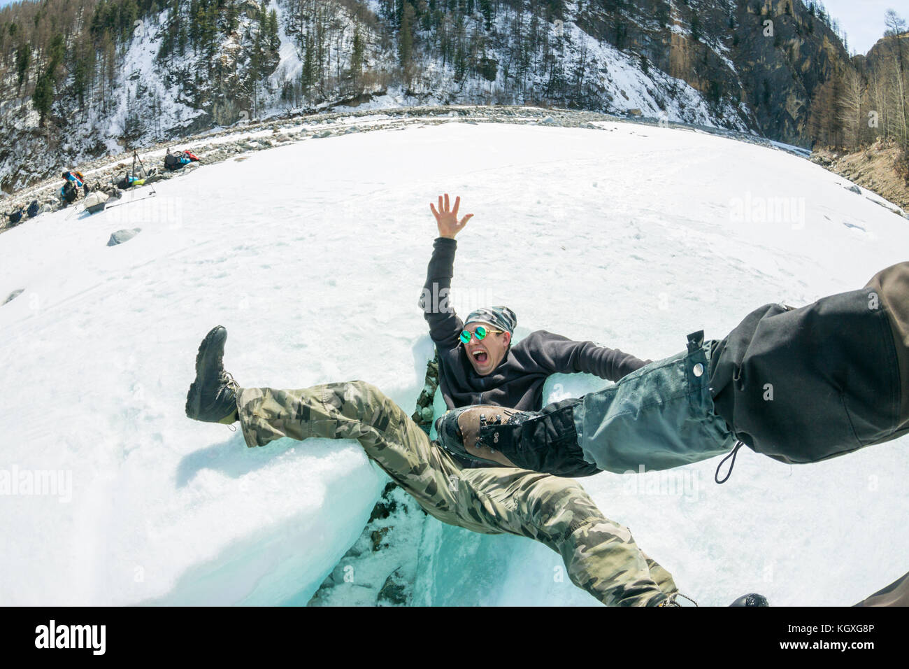 Der Mann fällt aus die Schreie von einem Schlag auf das Knacken des Gletschers. Stockfoto