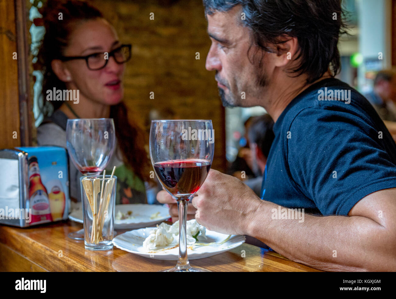 Kunden genießen Sie Tapas und Wein in einer Tapas Bar in Barcelona, Spanien Stockfoto